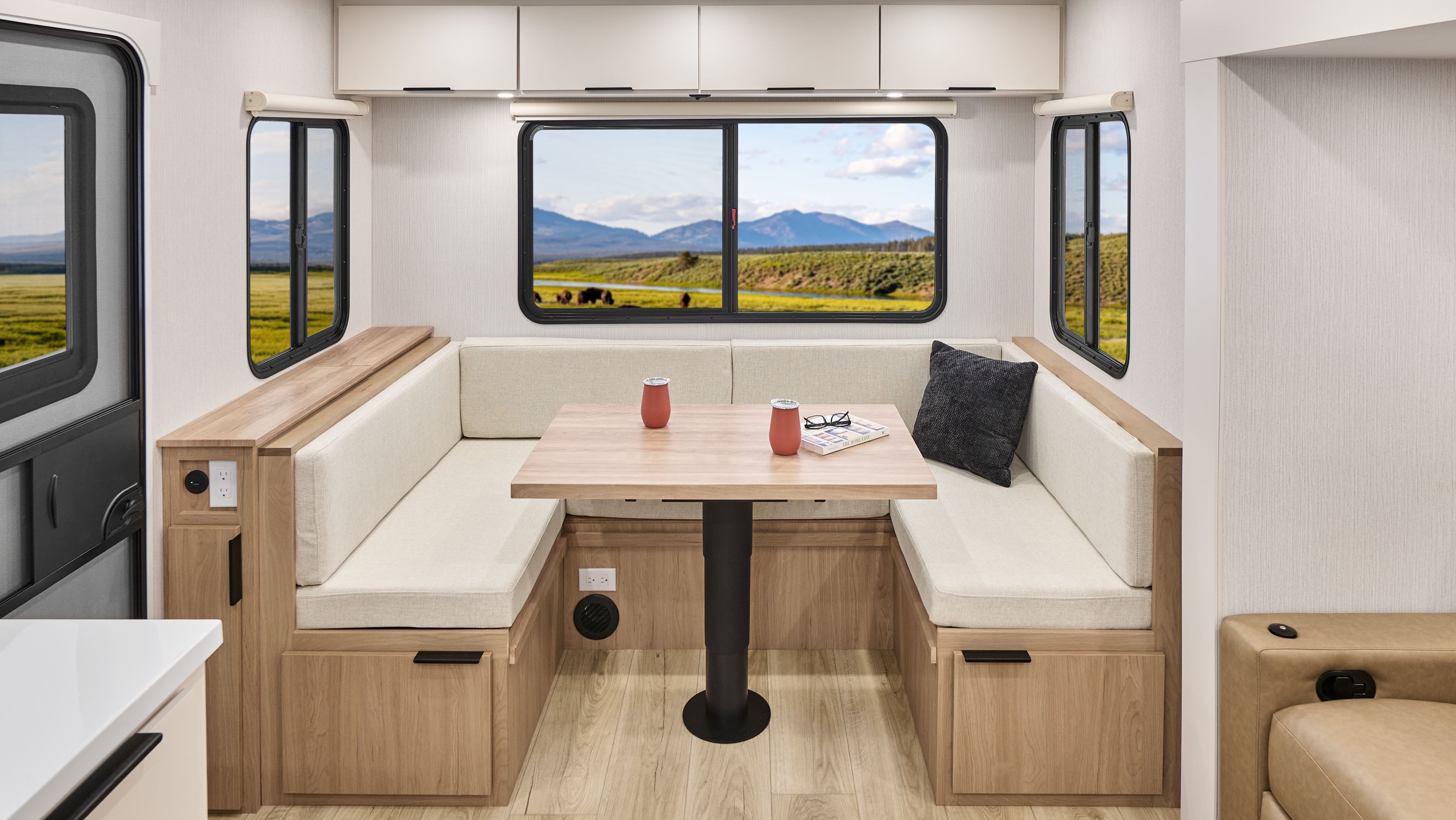 2026 Winnebago Thrive 25RLS — Comfortable, three-sided dinette seating inside a Thrive 25RLS, with storage available under the seating and overhead.