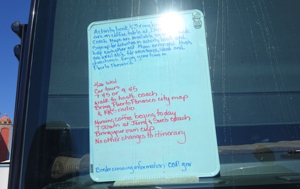 White board with information on it in the tour guide's RV front window.
