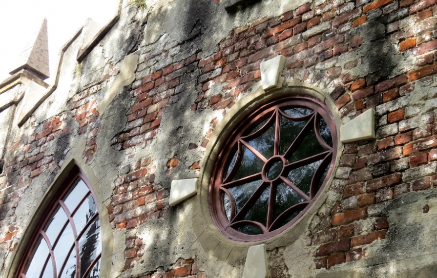 Charleston Masonry with beautiful window among brick exterior.