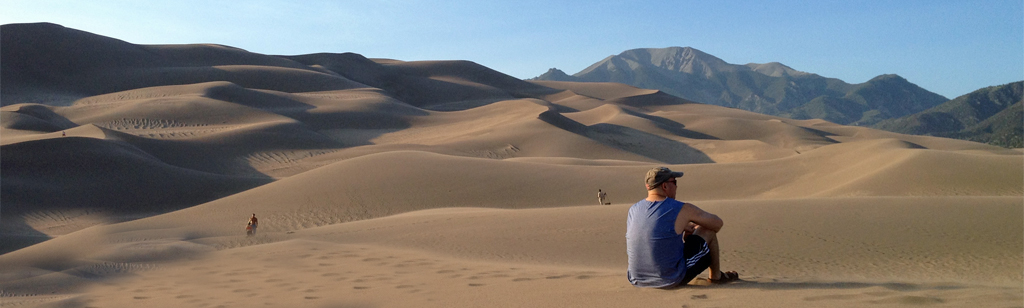Man sitting on sand dune.