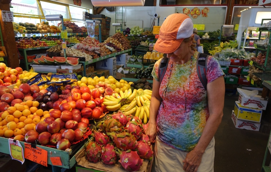 Woman next to fruit display at a market.