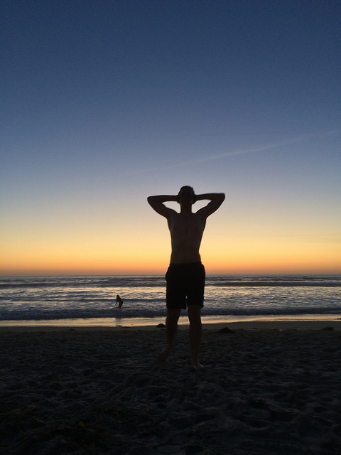 Silhouette of man on the beach at sunset. 