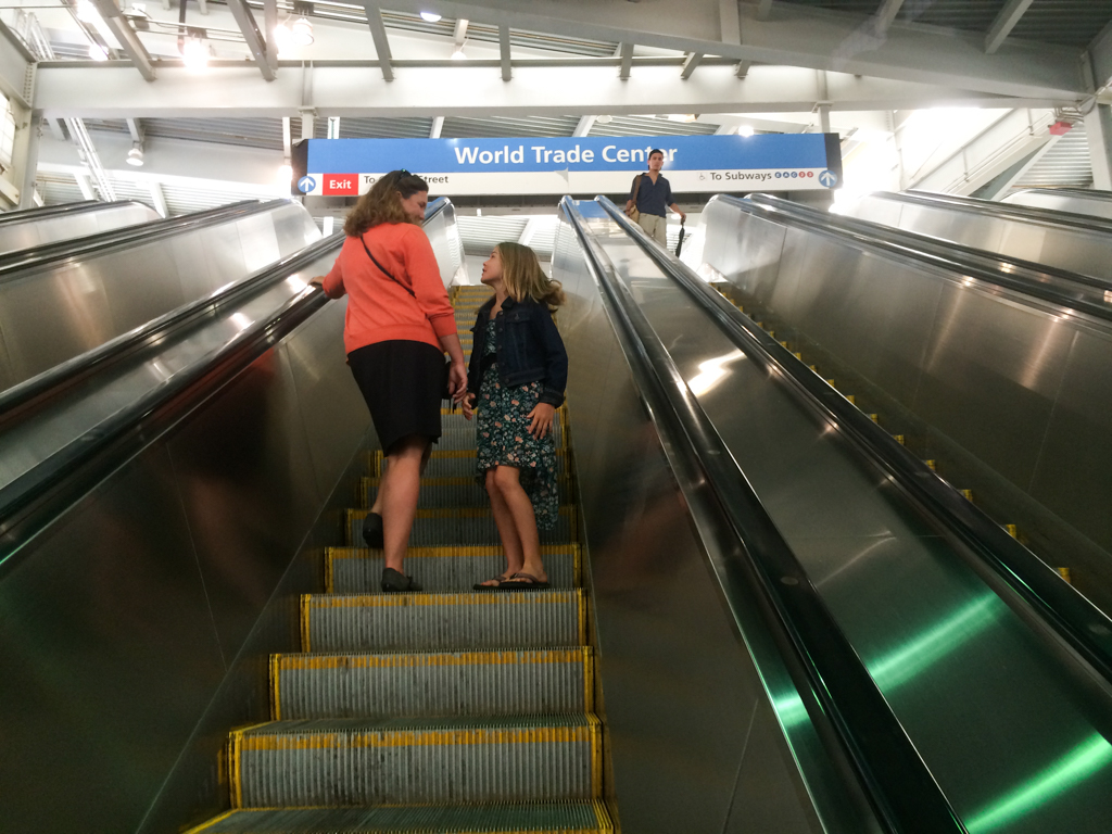 Two ladies on their way up an escalator in the subway.