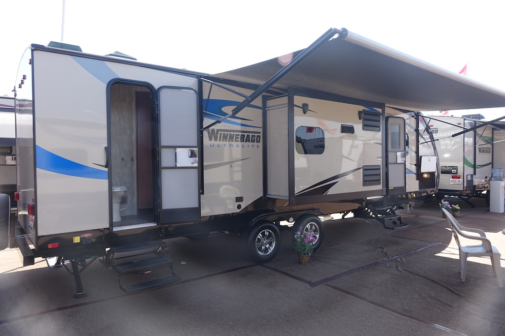 Winnebago Ultralite with awning out among product display.