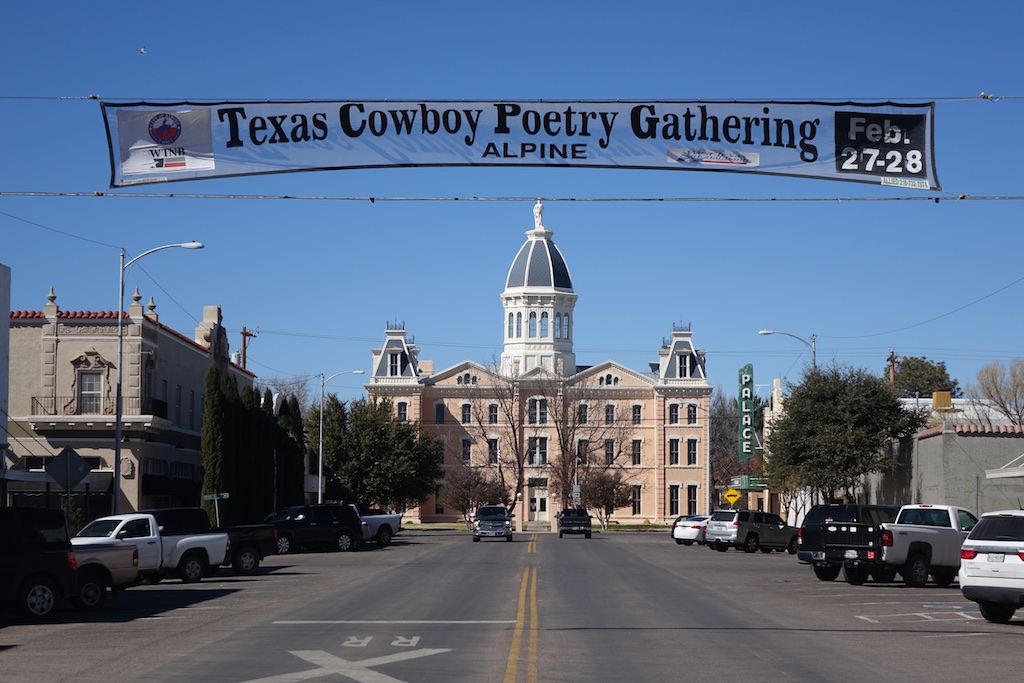 Downtown view of Marfa, Texas with banner across the street that reads, "Texas Cowboy Poetry Gathering."