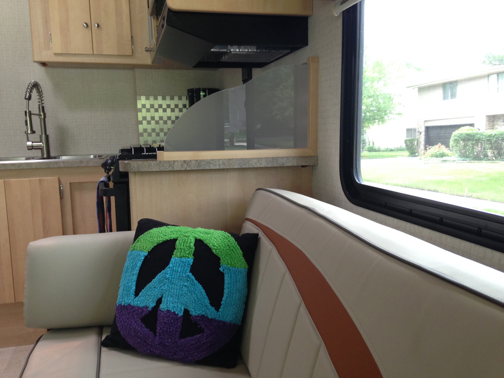 Pillow with peace sign on the RV's couch.