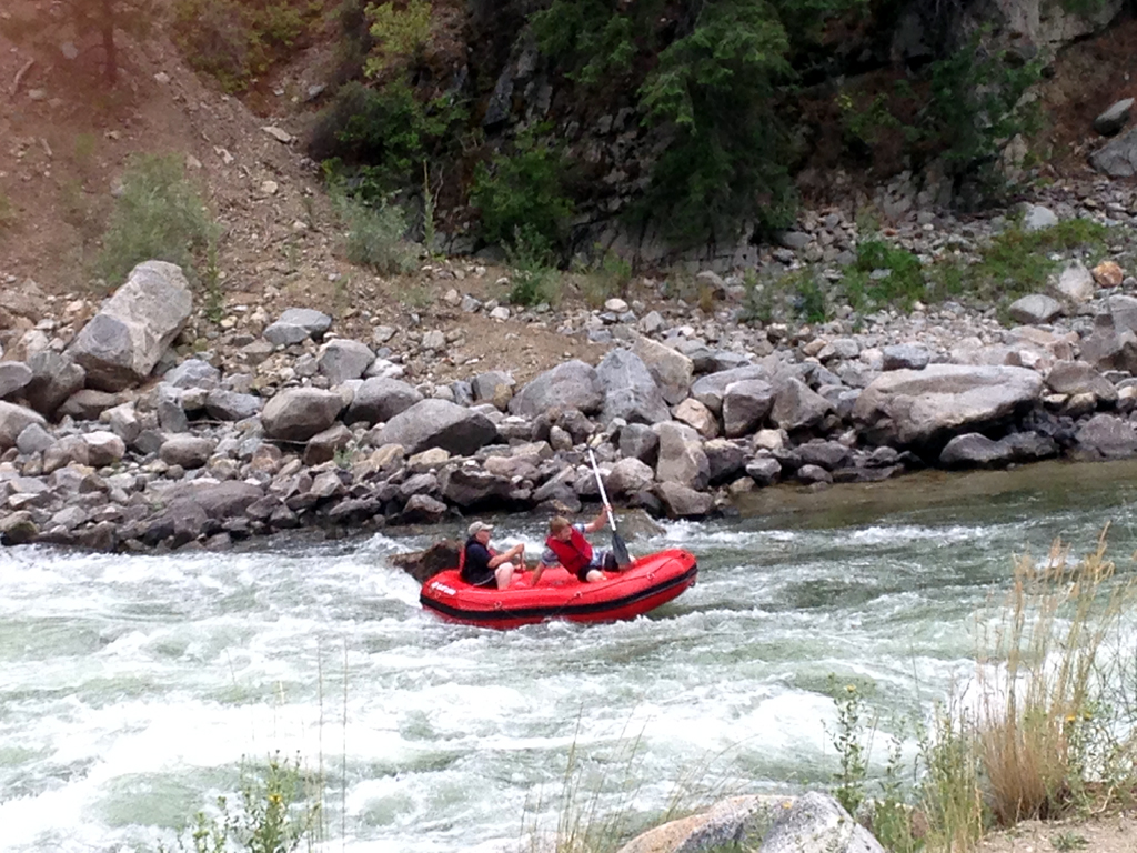 Two people in a raft going down a river.