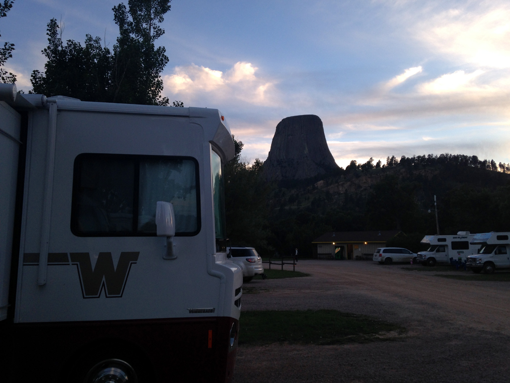 Front of Winnebago with Devil's Tower in the background with the sunsetting.