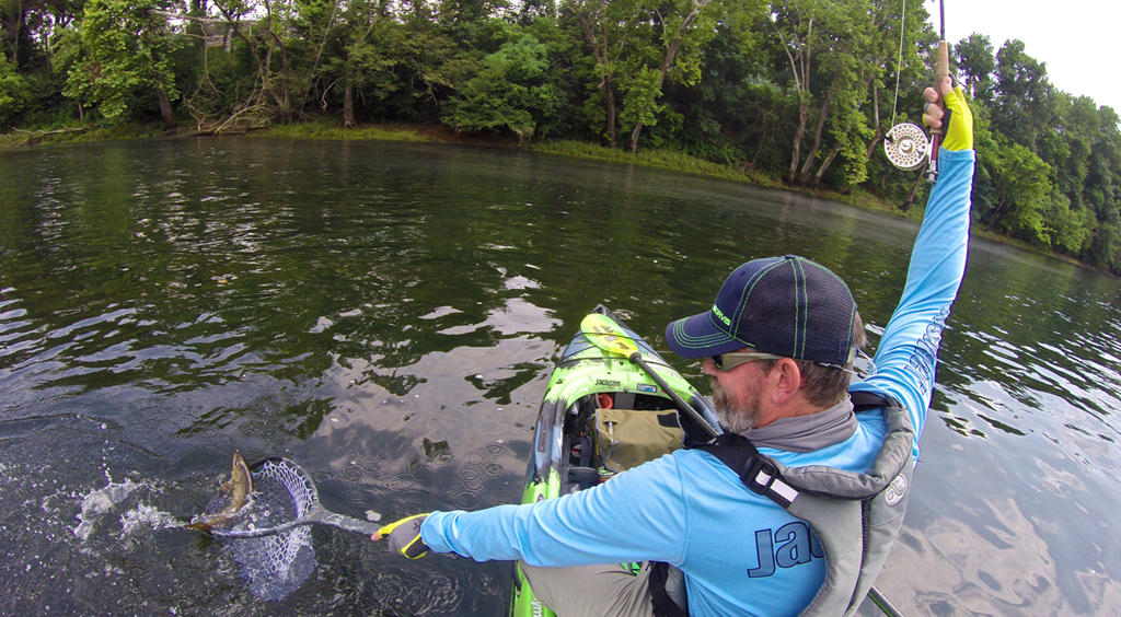Damon catching brown trout in kayak