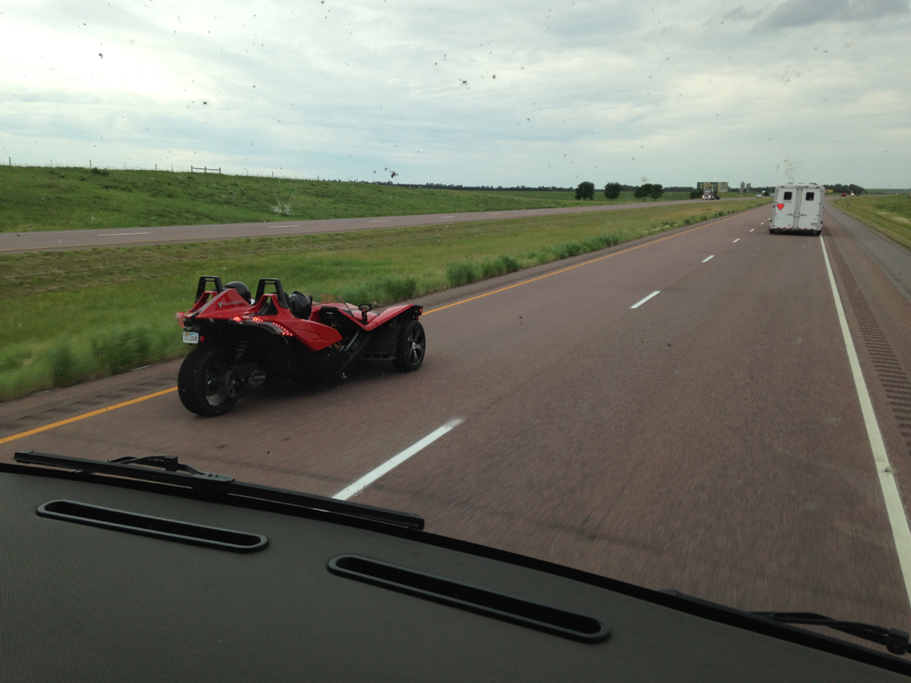 Passing a red slingshot vehicle on the highway.