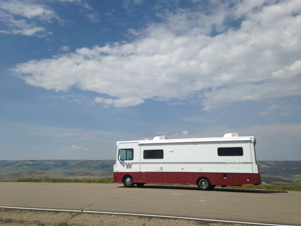 Winnebago Brave on the road with rolling hillsides in the background.