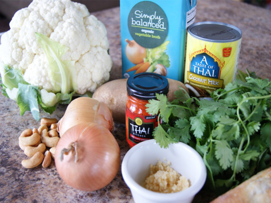 Ingredients on table for Adinaro Curried Cauliflower Bisque such as vegetable broth, coconut milk, onions, cashews, etc... 