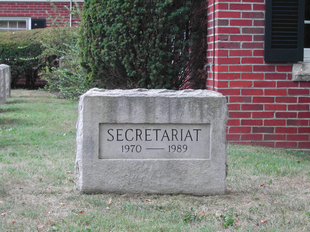 Stone marker in the ground reading "Secretariat 1970-1989."