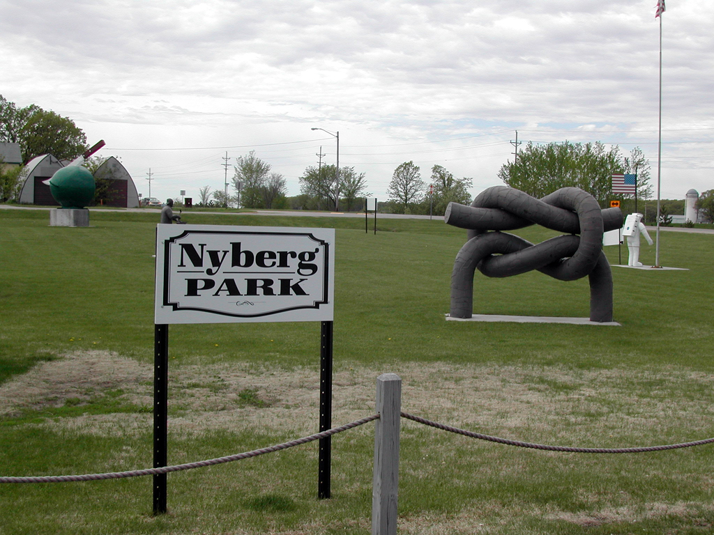 Sculptures on grass behind sign for Nyberg Park.