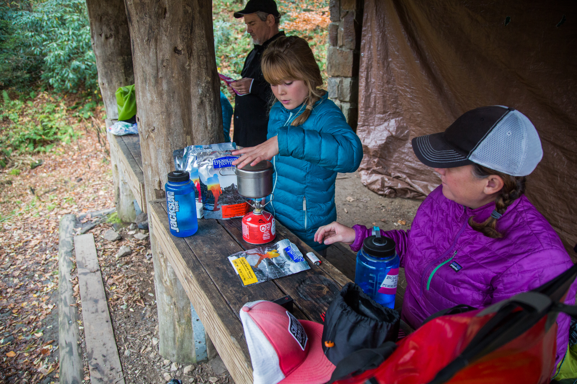 People making dinner on the front porch of the shelter.