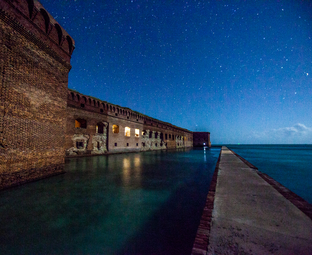 Brick built Fort Jefferson along the water with the starry night sky above.