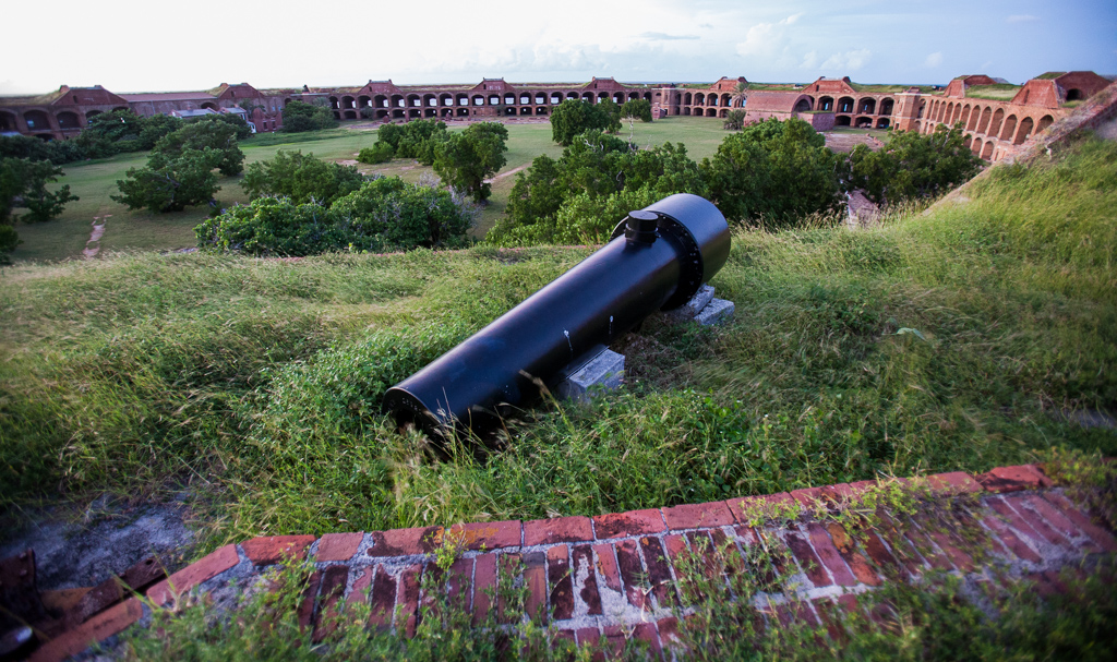 View of the courtyard at Fort Jefferson with the building creating a circle around a grassy and tree covered green.