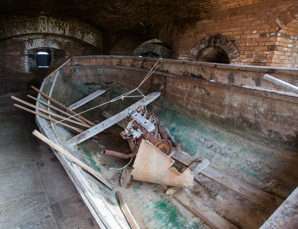 Very worn, old chug boat sitting in a room in Fort Jefferson.