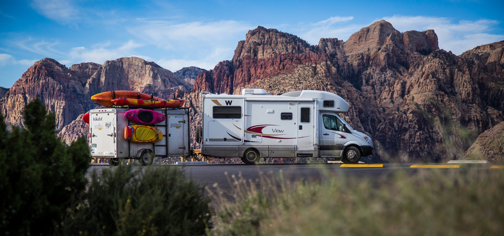 Winnebago View with toy trailer with Red Rocks National Monument in the background.