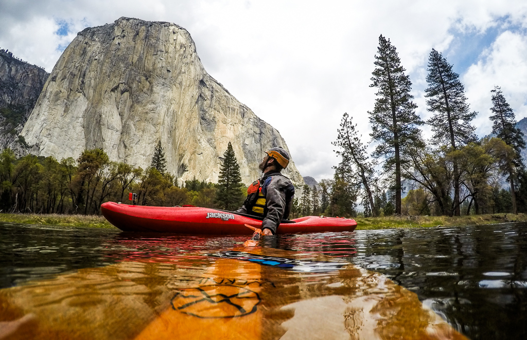Peter in a kayak on the water looking up at El Capitan.