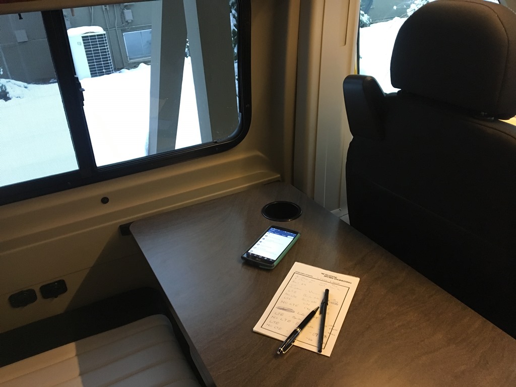 Phone and pad of paper sitting on table in RV.