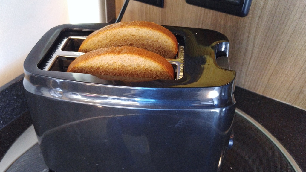 Two pieces of toast popping out of toaster.
