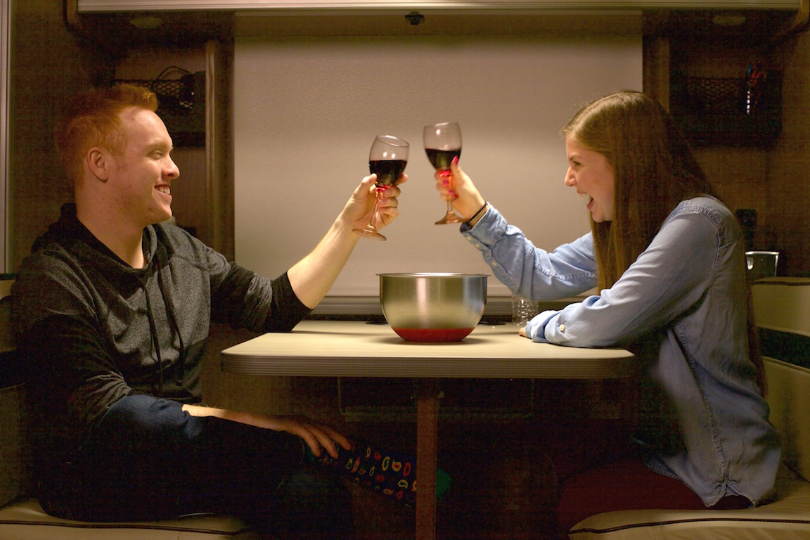 Alyssa and Heath Padgett toasting with wine at their Winnebago Brave dinette.