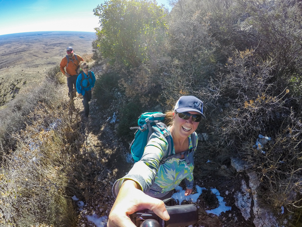 Kathy taking a selfie of she, Abby and Peter walking on narrow trail high above the ground below.