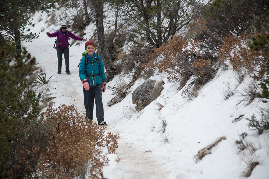 Abby and Kathy making their way down a snow covered path between the trees.