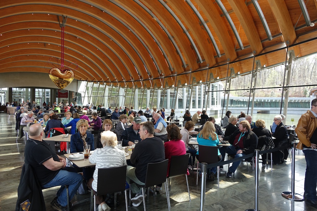 Museum cafe filled with people at dozens of tables.