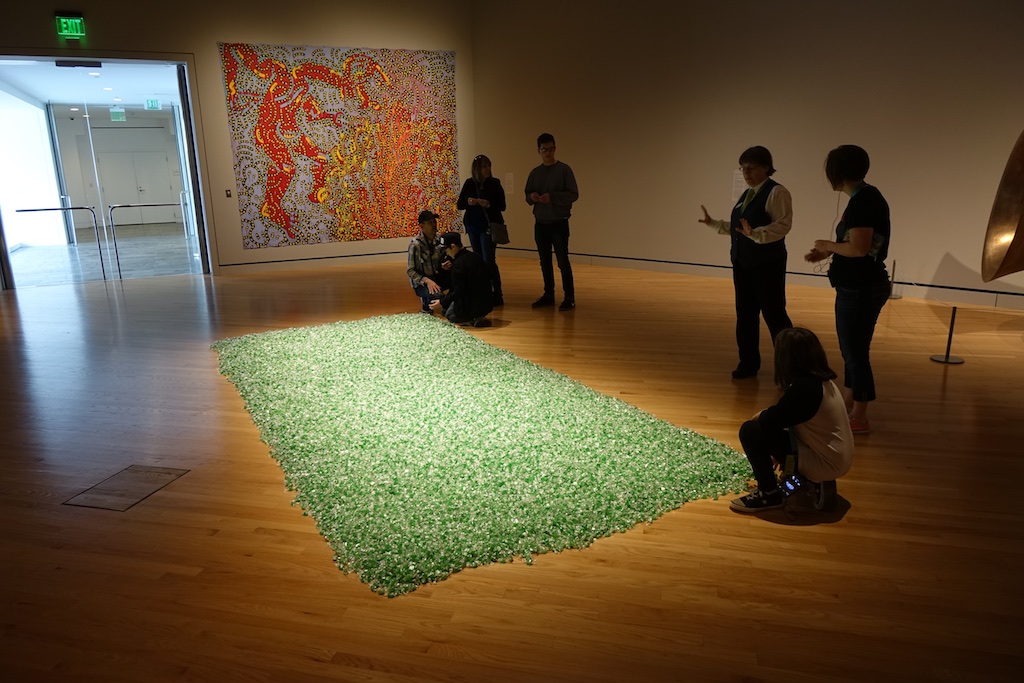 People viewing a piece of art made of candy.
