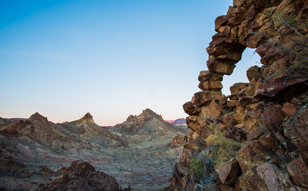 Unique rock formation among rough desert terrain.