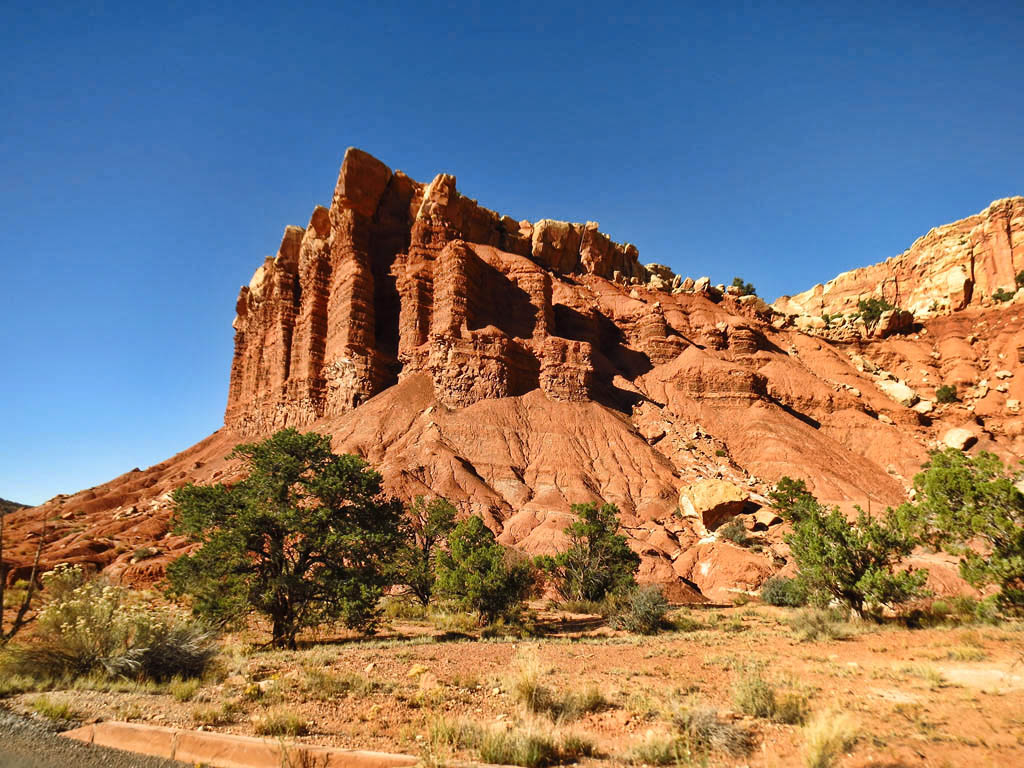 Red canyons rising above desert landscape.