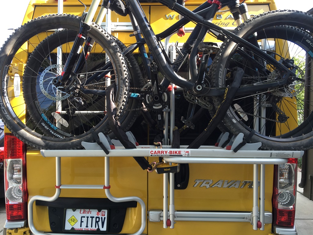 Bikes locked on the rack on the back of a Winnebago Travato.