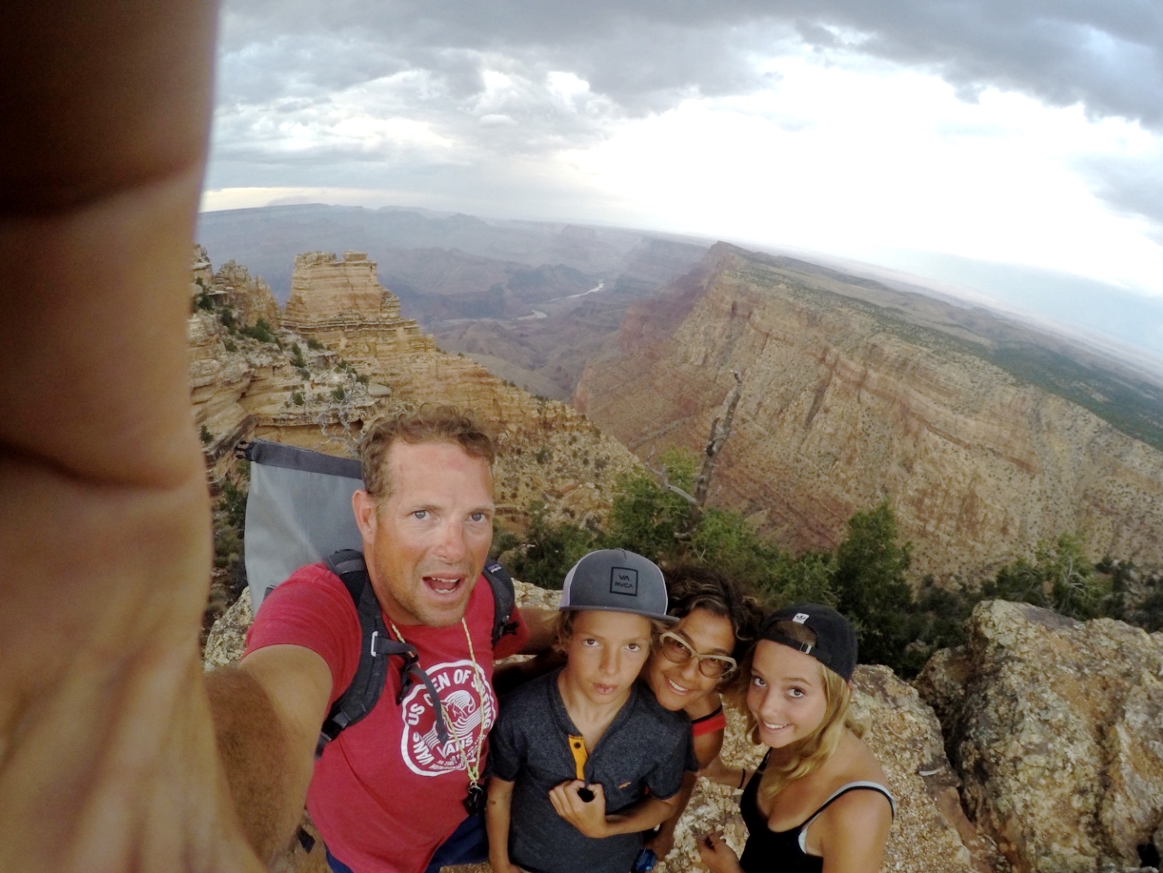 Family selfie with canyons and river below.