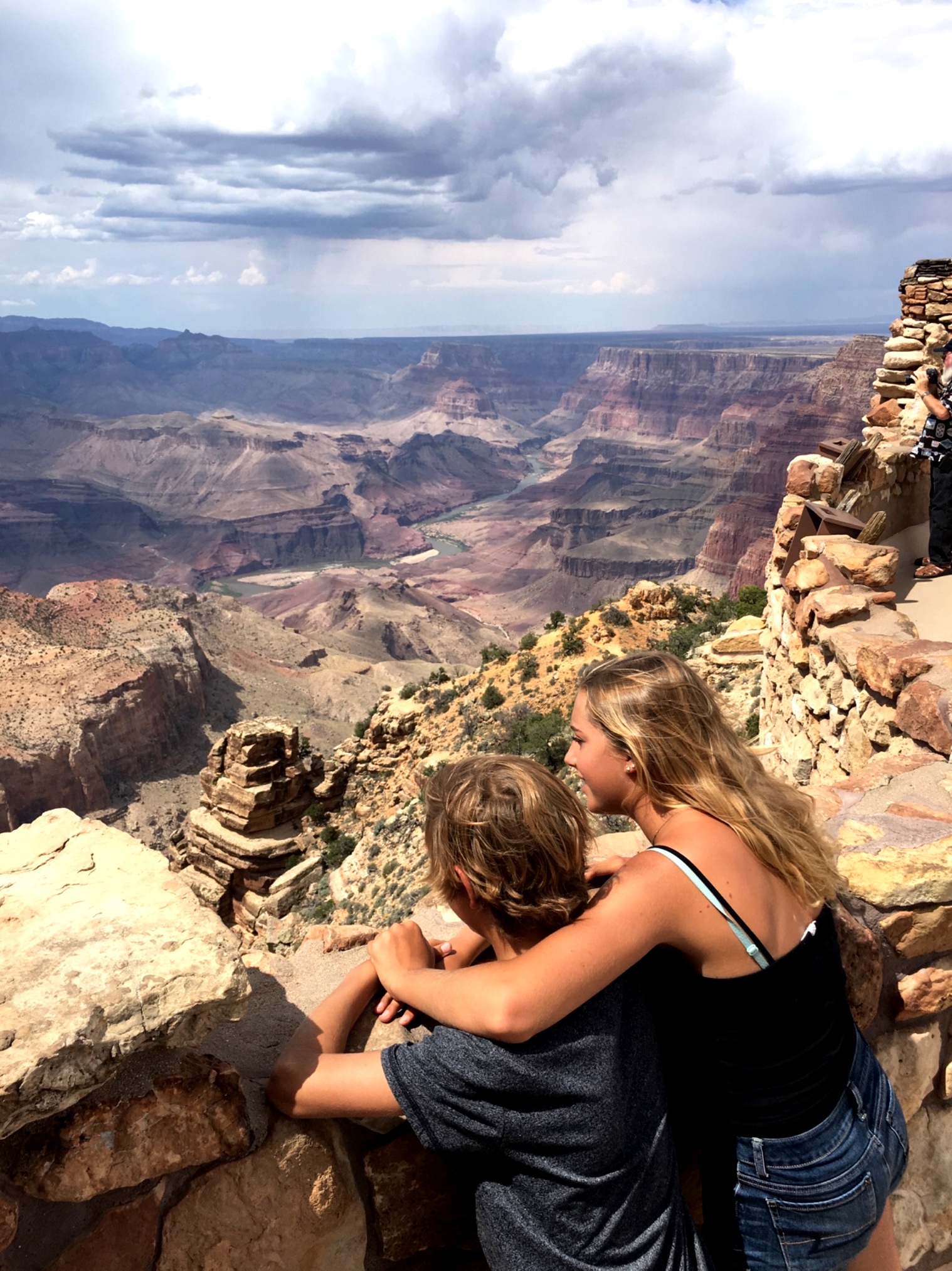 Boy and girl looking out over the Grand Canyons.