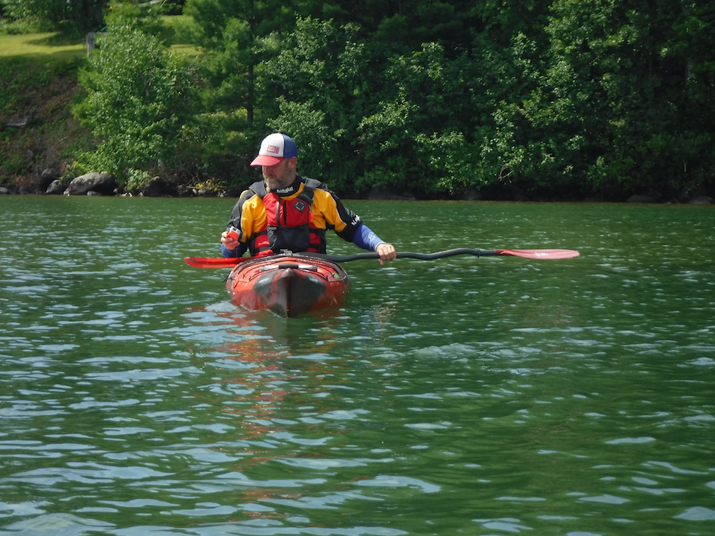Man in kayak adjusting camera.