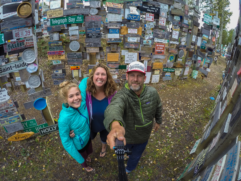 Peter, Kathy, and Abby standing among the many rows of Sign Forest.
