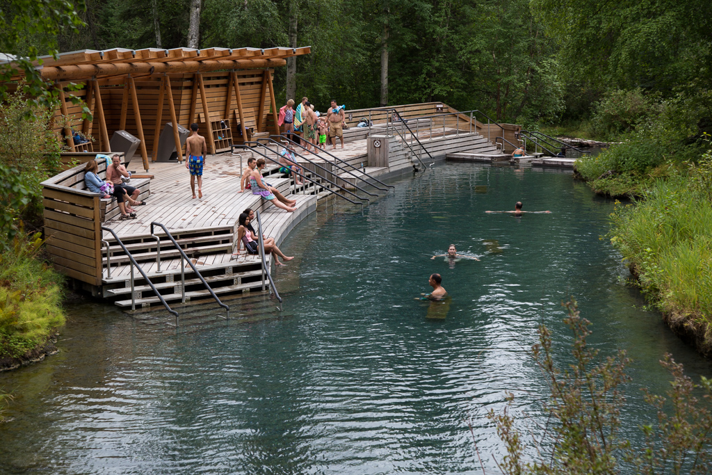 People on the steps and in the water at the Laird Hot Springs. 