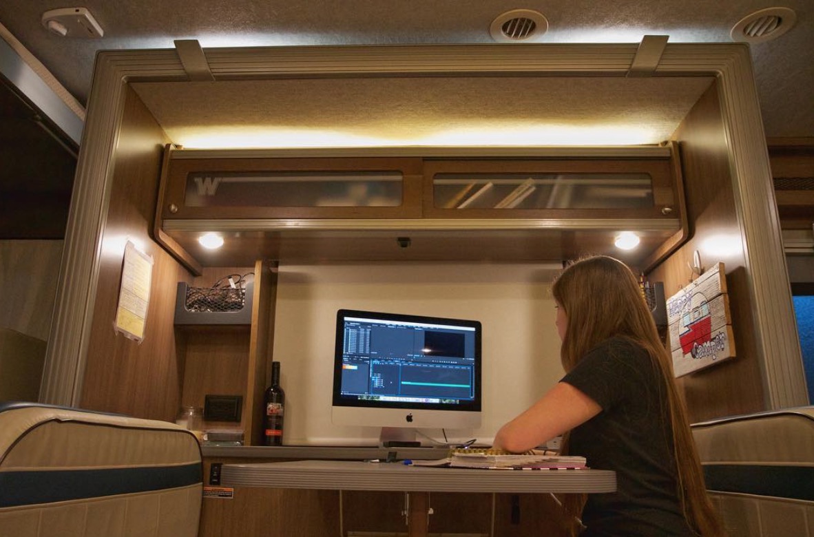 Woman working on a computer at motorhome dinette
