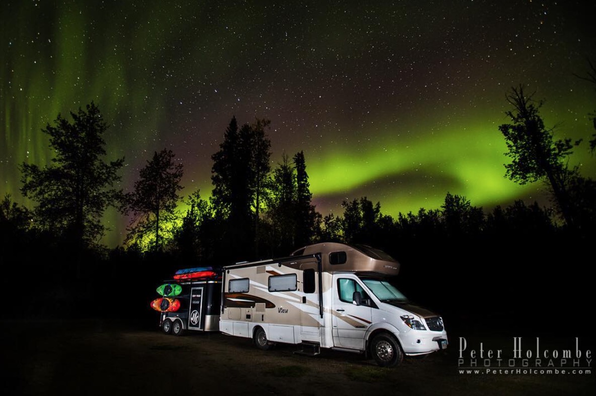 Winnebago View under the stars with Northern Lights dancing through the sky.
