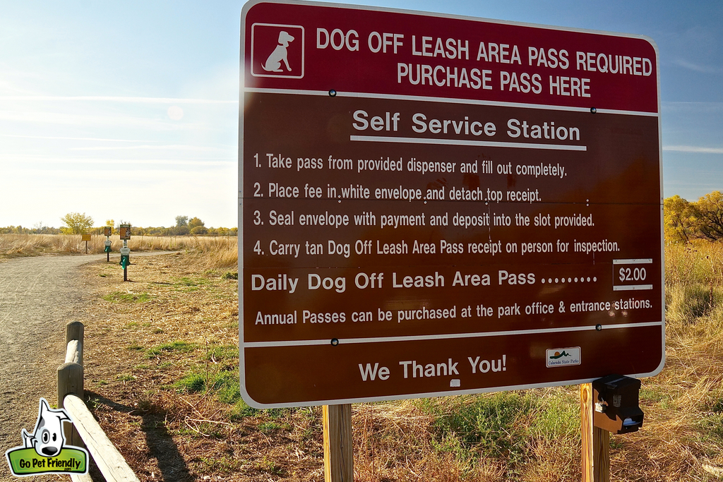 Sign showing off leash dog park rules.