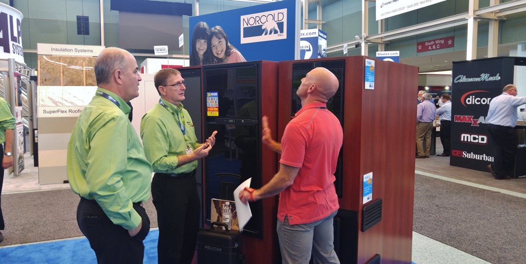 Norcold display booth at the RVIA trade show in Louisville, Kentucky, three gentlemen discussing the latest technology in refrigerators