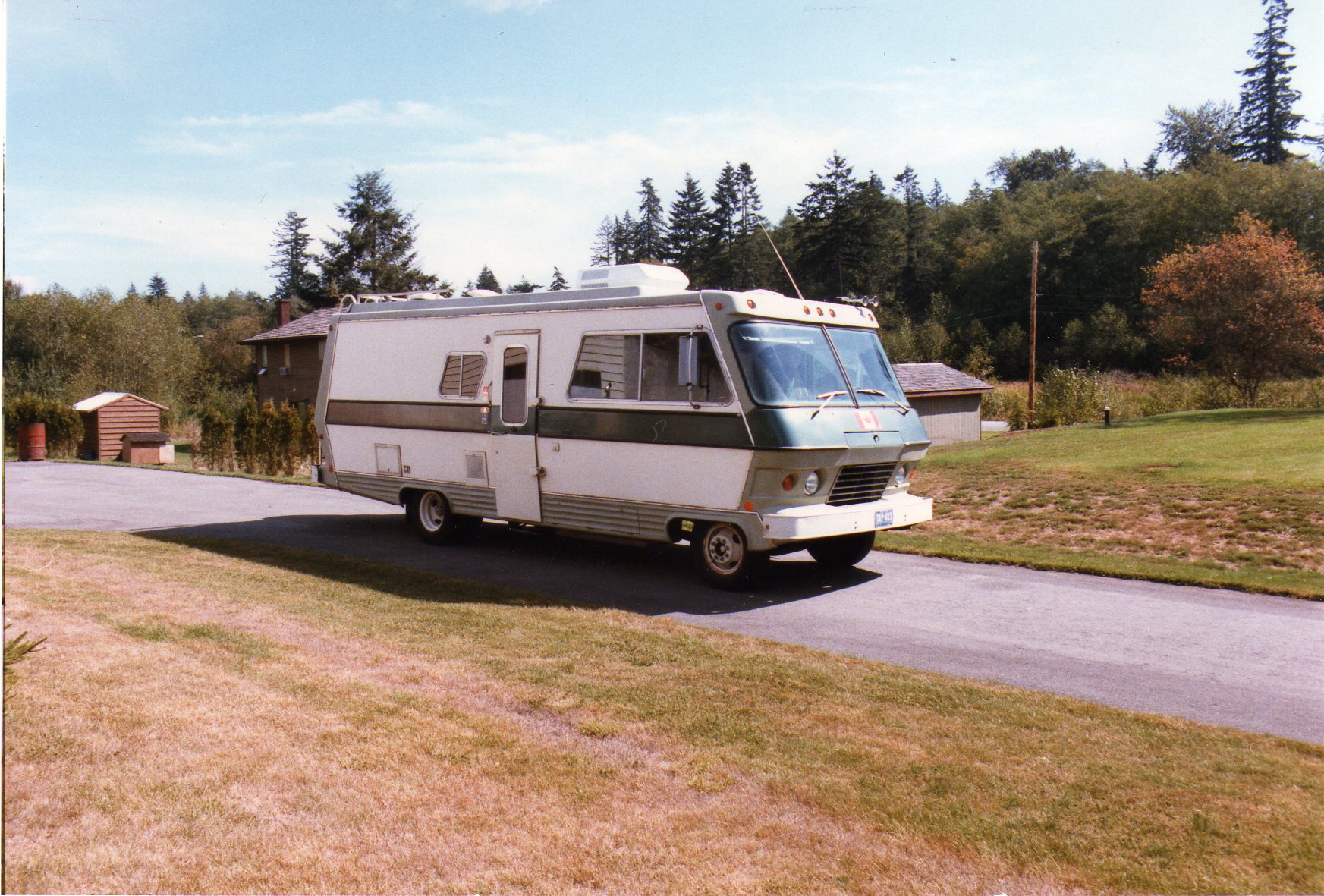 Old RV parked on a road.