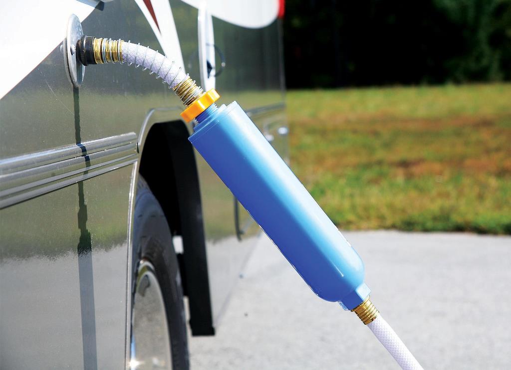 Portable water filter installed in line with fresh water hose and attached to RV hookup point