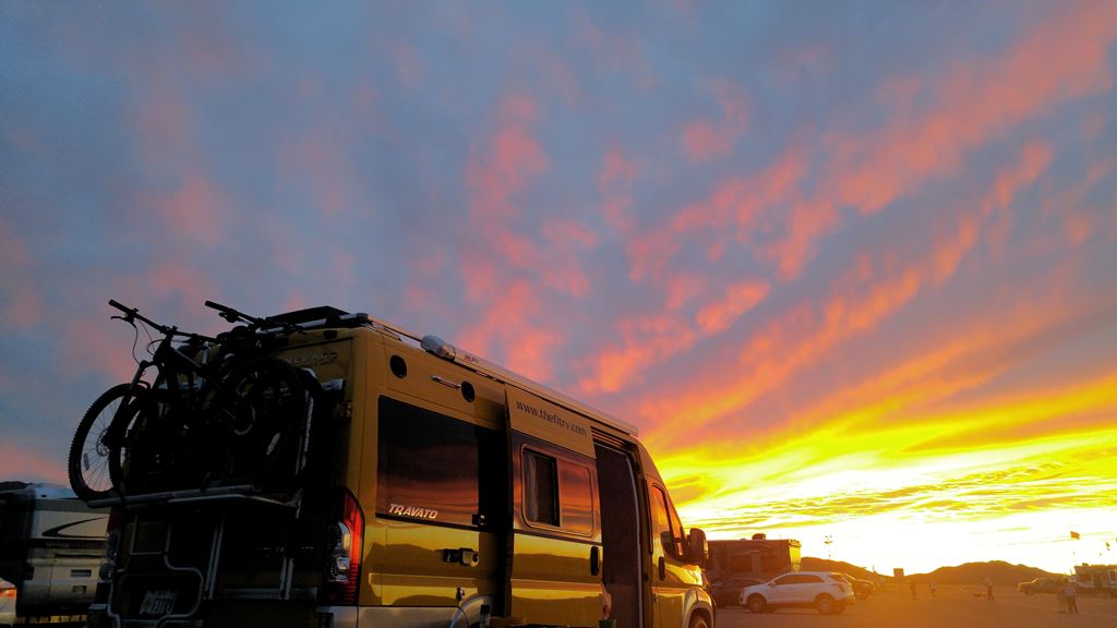 Winnebago Travato with colorful sky overhead.