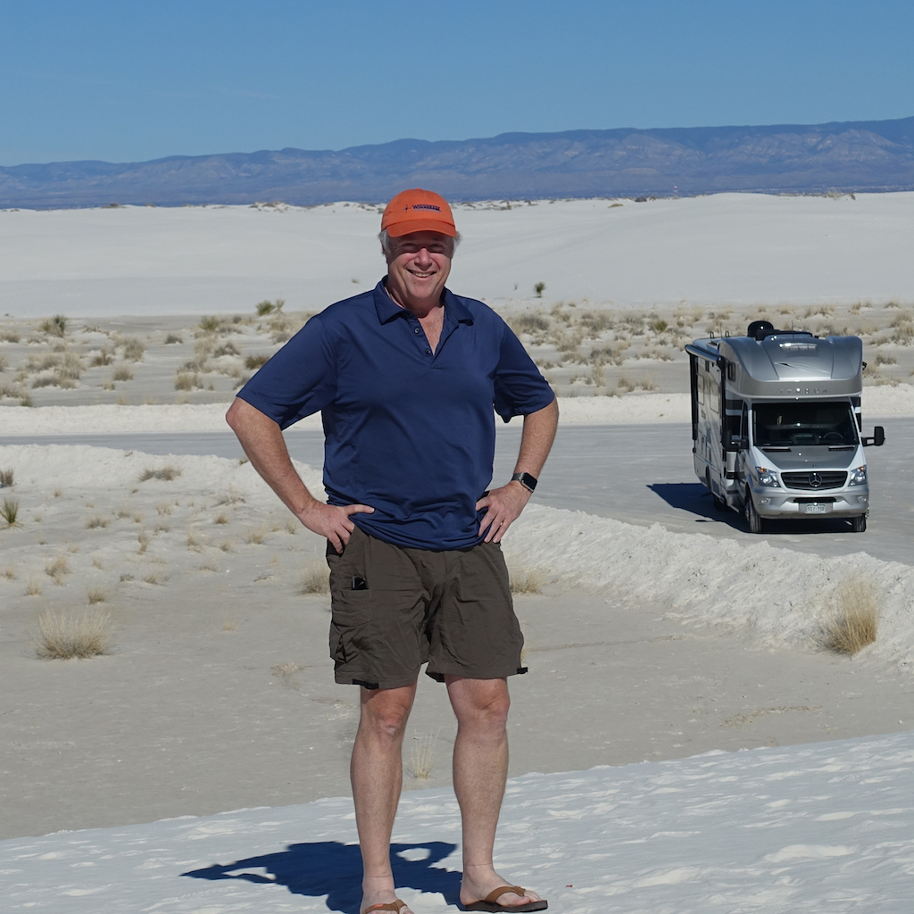 Winnebago contributer, Don Cohen, posing for the camera with his Winnebago Navion in the desert background.