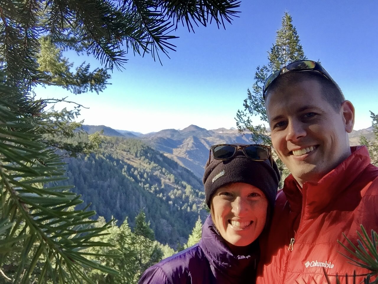 Couple taking a selfie with mountains in the background.