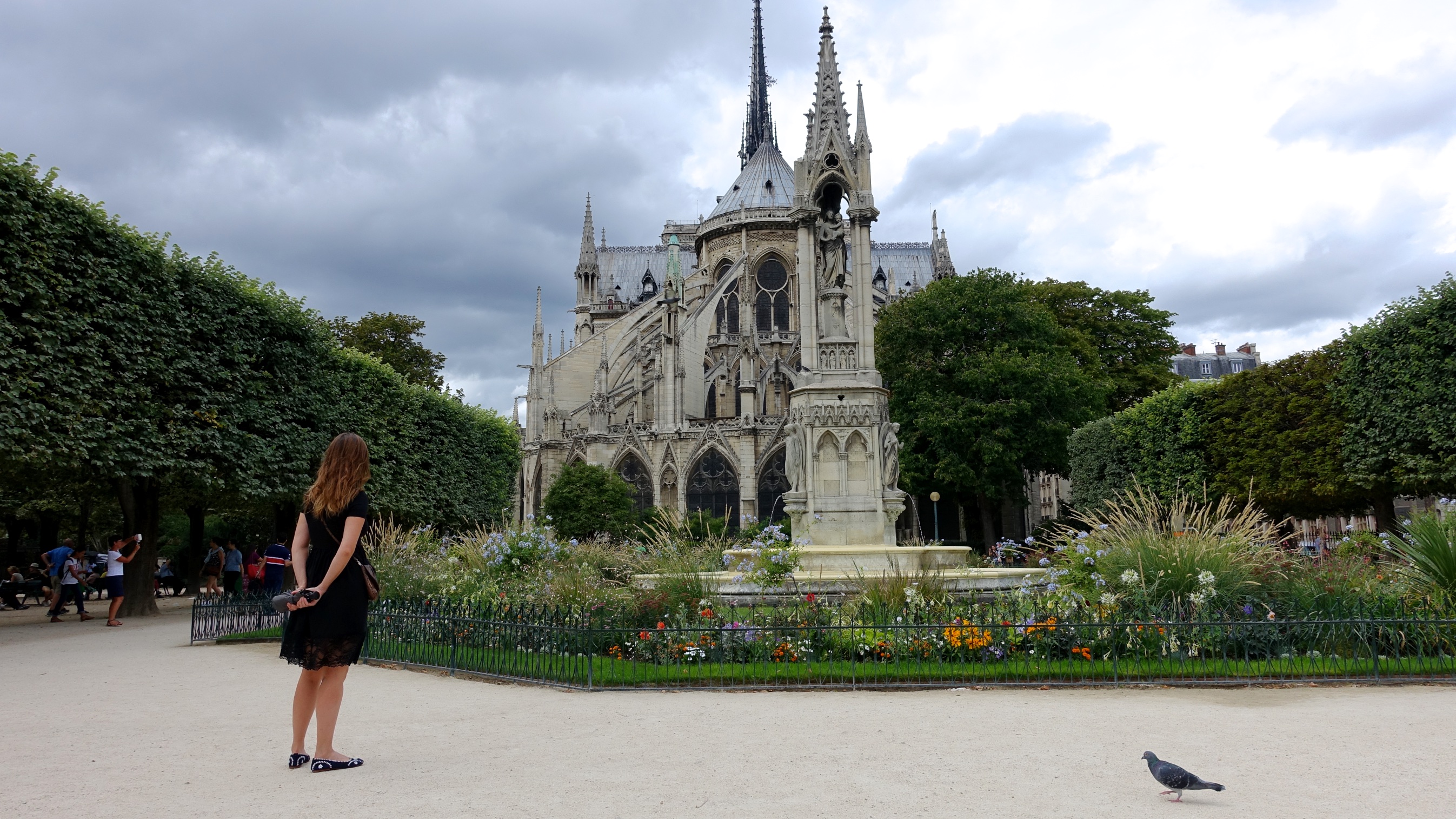 Woman standing in the gardens near Notre Dame in Paris, France.