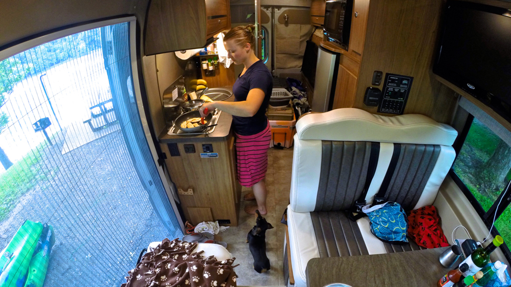 Woman making food in the kitchen of the Winnebago Micro Minnie.
